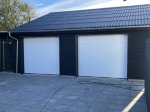 Sort garage med to hvide porte